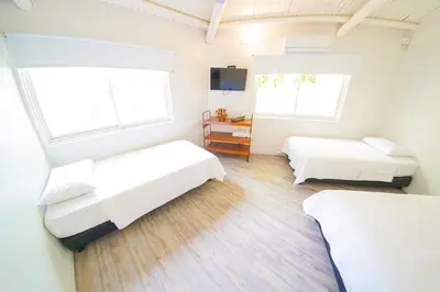 a bedroom with two beds and two windows at Quinta del Mar El Paraiso in Tolú