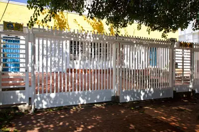 a white fence in front of a building at QuillaHost Guesthouse in Barranquilla