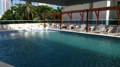 a swimming pool with white chairs and a swimming pool at Apartamento Boutique Cartagena in Cartagena de Indias