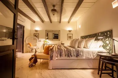 a bedroom with a large bed and a table at Casa de Alba Hotel Boutique in Cartagena de Indias