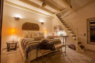 a bedroom with a large bed and a staircase at Casa de Alba Hotel Boutique in Cartagena de Indias
