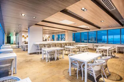 a dining room with tables and chairs and windows at Holiday Inn Express - Barranquilla Buenavista by IHG in Barranquilla
