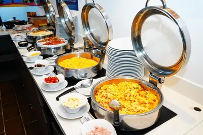 a buffet with many dishes of food on a counter at Holiday Inn Express - Barranquilla Buenavista by IHG in Barranquilla