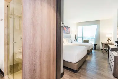 a hotel room with two beds and a shower at Holiday Inn Express - Barranquilla Buenavista by IHG in Barranquilla