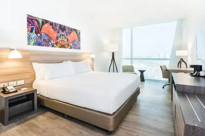 a hotel room with a bed and a desk and a window at Holiday Inn Express - Barranquilla Buenavista by IHG in Barranquilla