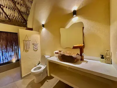 a bathroom with a toilet and a sink with a mirror at Awa de Mar Playa in Tolú