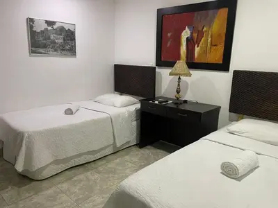 a room with two beds and a table with a lamp at Hotel Fegali Art Boutique in Cartagena de Indias