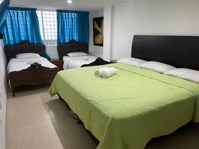 a bedroom with two beds with green sheets and avertisement at Hotel Fegali Art Boutique in Cartagena de Indias