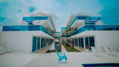 a building with blue windows and a blue chair at Palma Linda Coveñas by Bernalo Hotels in Coveñas