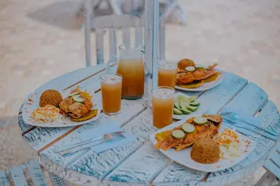 a table with plates of food and glasses of orange juice at Palma Linda Coveñas by Bernalo Hotels in Coveñas