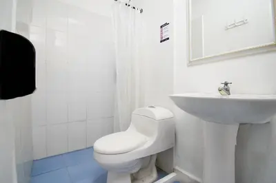 a white bathroom with a toilet and a sink at Palma Linda Coveñas by Bernalo Hotels in Coveñas