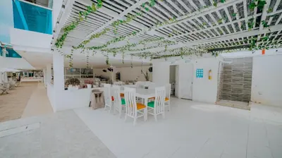 a room with white tables and chairs and a ceiling at Palma Linda Coveñas by Bernalo Hotels in Coveñas