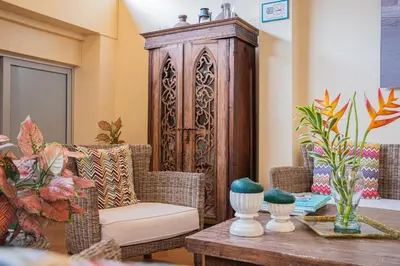 a living room with a table and a wooden cabinet at Posada La Fe in Cartagena de Indias
