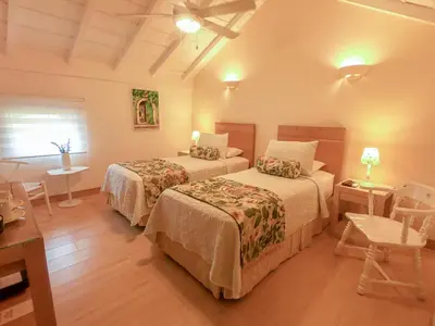 a hotel room with two beds and a table at Posada La Fe in Cartagena de Indias