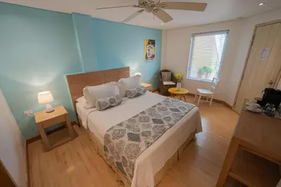 a bedroom with a bed and a blue wall at Posada La Fe in Cartagena de Indias