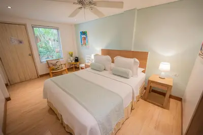 a bedroom with a large white bed and a window at Posada La Fe in Cartagena de Indias