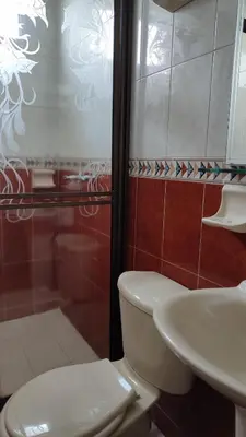 a bathroom with a toilet and a sink at Hotel Dorado BAQ in Barranquilla