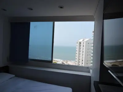 a bedroom with a window with a view of the ocean at Apartamento Laguito Bocagrande in Cartagena de Indias