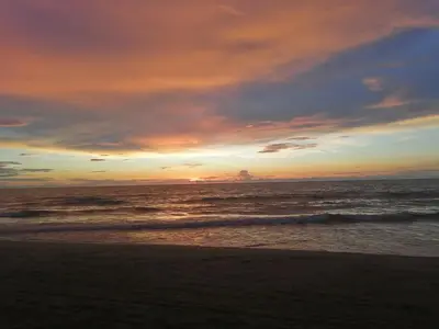 a sunset on the beach with the ocean at Manzanillo Beach in Cartagena de Indias
