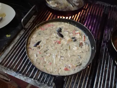 a pizza cooking in a pan on a grill at Manzanillo Beach in Cartagena de Indias