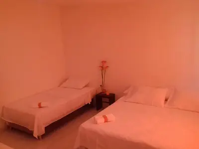 two beds in a room with pink walls at Manzanillo Beach in Cartagena de Indias