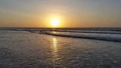 a sunset on a beach with the ocean at Manzanillo Beach in Cartagena de Indias