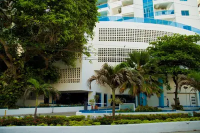 a building with palm trees in front of it at Apartamento Vista Mar 1707 in Cartagena de Indias