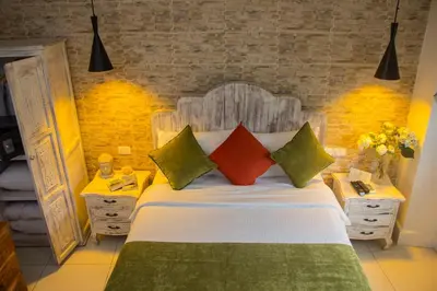 a bedroom with a bed with colorful pillows at Voilá Signature Casa Isabel in Cartagena de Indias
