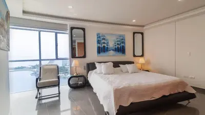 a bedroom with a bed and a chair in it at Poseidon Lake Apartments in Cartagena de Indias