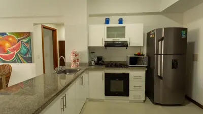 a kitchen with a stainless steel refrigerator and white cabinets at Poseidon Lake Apartments in Cartagena de Indias