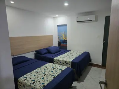 a hotel room with two beds and a window at Hotel Plaza 43 in Barranquilla