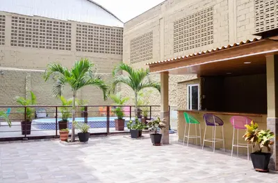 a patio with palm trees and a swimming pool at Hotel Sofichic Barranquilla in Barranquilla