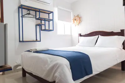a bedroom with a bed with a blue and white blanket at Hotel Aquarius in Barranquilla