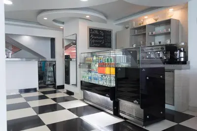 a restaurant with a bar with a checkered floor at Hotel Aquarius in Barranquilla