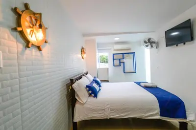 a bedroom with a bed and a clock on the wall at Hotel Aquarius in Barranquilla
