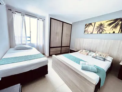 a bedroom with two beds and a painting on the wall at Apartamento piso 12 y 17 Welch in Cartagena de Indias