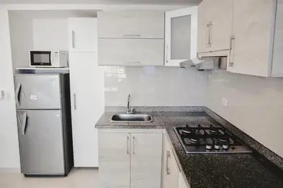 a white kitchen with a sink and a refrigerator at Apartamento piso 12 y 17 Welch in Cartagena de Indias