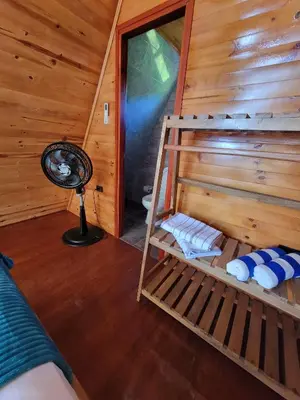 a room with a bunk bed in a log cabin at Isla Los Erizos EcoHouse in Isla Grande
