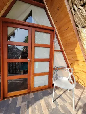 a door and a chair in front of a house at Isla Los Erizos EcoHouse in Isla Grande