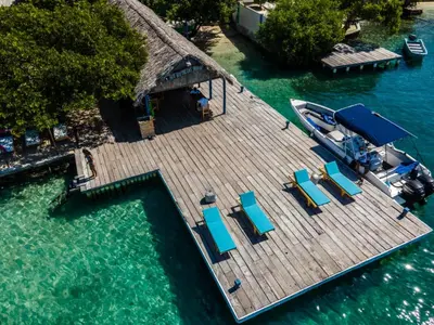 an aerial view of a dock with chairs and a boat at Isla Los Erizos EcoHouse in Isla Grande