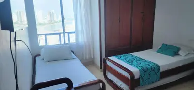 a small room with two beds and a window at Cartagena El Laguito Apto cerca a la playa in Cartagena de Indias