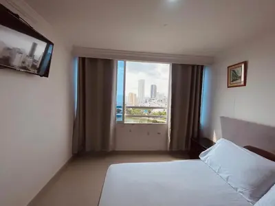 a hotel room with a bed and a large window at Cartagena El Laguito Apto cerca a la playa in Cartagena de Indias