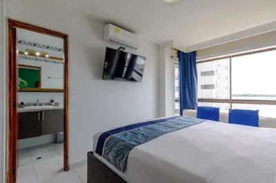a bedroom with a bed and a sink and a mirror at Cartagena - Torremarina in Cartagena de Indias