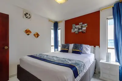 a bedroom with a bed with a red wall at Cartagena - Torremarina in Cartagena de Indias