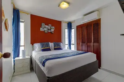 a bedroom with a large bed with orange walls at Cartagena - Torremarina in Cartagena de Indias