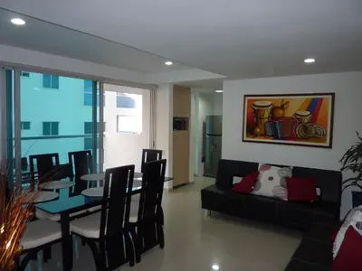 a living room with a black couch and a table at Apartmento Edificio Porto Vento in Cartagena de Indias