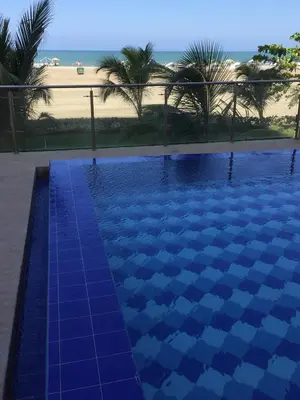 a blue swimming pool with a view of the beach at Apartmento Edificio Porto Vento in Cartagena de Indias