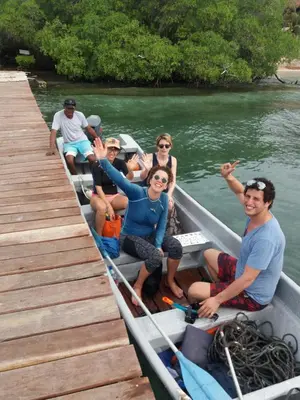 a group of people sitting in a boat on the water at Ecohotel Arte y Aventura in Isla Grande