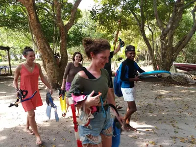 a group of people walking around in a park at Ecohotel Arte y Aventura in Isla Grande