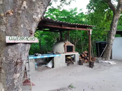 an outdoor oven with a sign next to a tree at Ecohotel Arte y Aventura in Isla Grande